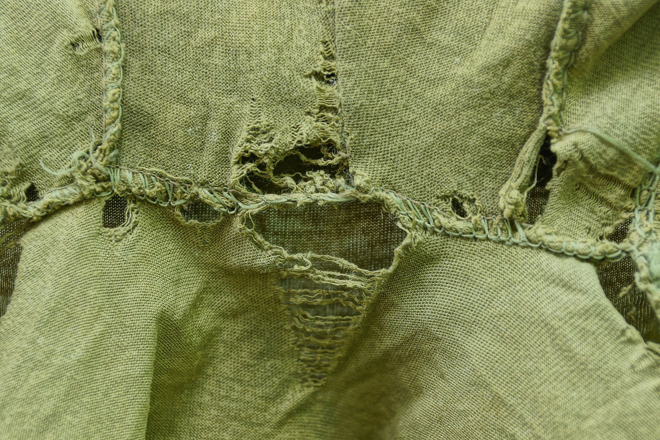 green fabric texture of torn clothes